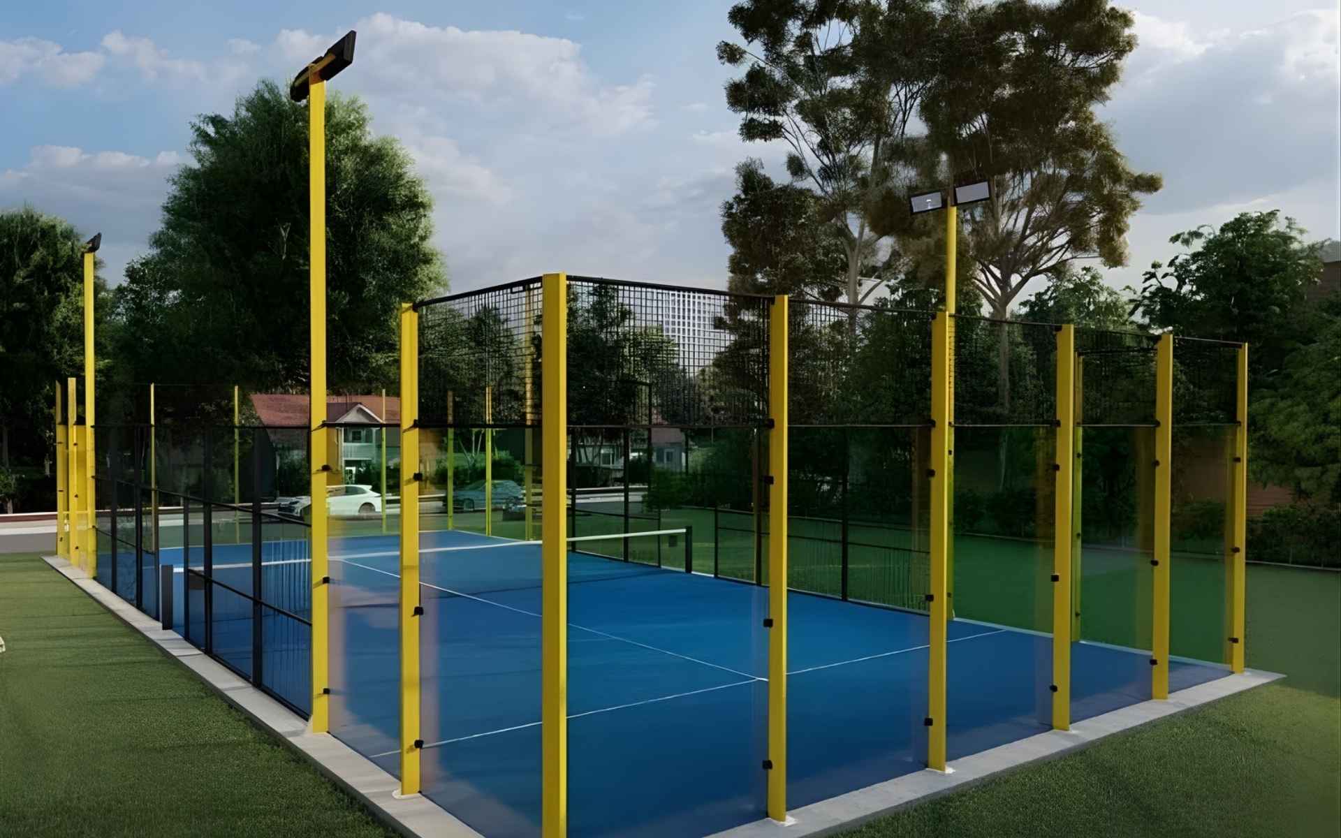 Fotografía de una pista de pádel con barrotes amarillos y cristal