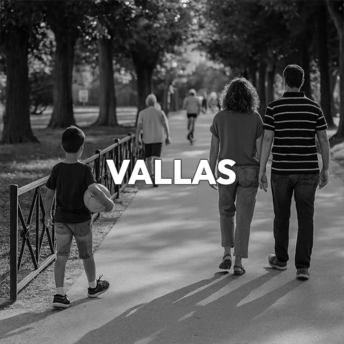 Una mesa de madera con bancos en un pinar y alrededor una familia comiendo en blanco y negro