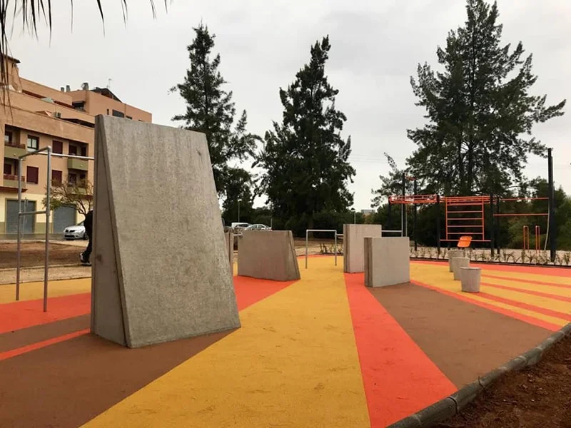 Espacio de calistenia de hormigón con suelo continuo en colores cálidos