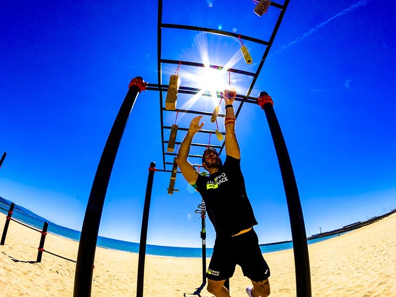 área de calistenia en una playa y una persona utilizándola